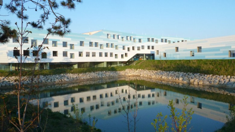 BORG Deutsch-Wagram, © Werner Ertl Modernes Gebäude mit blau-weißer Fassade und Teich im Vordergrund.