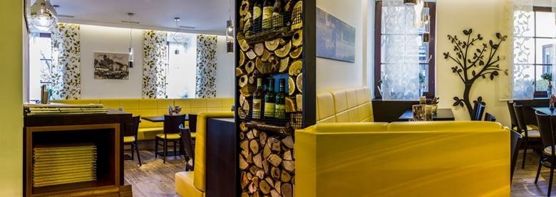 Restaurant, © Siebenbrunnerhof Innenansicht eines Restaurants mit gelben Sitzbänken und dekorativen Elementen.