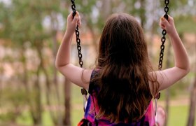 Schaukel, © pixabay Ein Kind schaukelt auf einer Schaukel im Freien, umgeben von Bäumen.