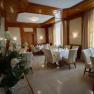 Speisesaal, © Siebenbrunnerhof Eleganter Speisesaal mit gedeckten Tischen, weißen Stühlen und Blumenarrangement.