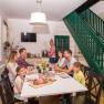 Winery Küssler, © Winzerhof Küssler Family sitting at a table in a modern dining room with a green staircase.