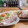 Winery Küssler, © Winzerhof Küssler Two sandwiches with ham, onions and vegetables on a wooden table.