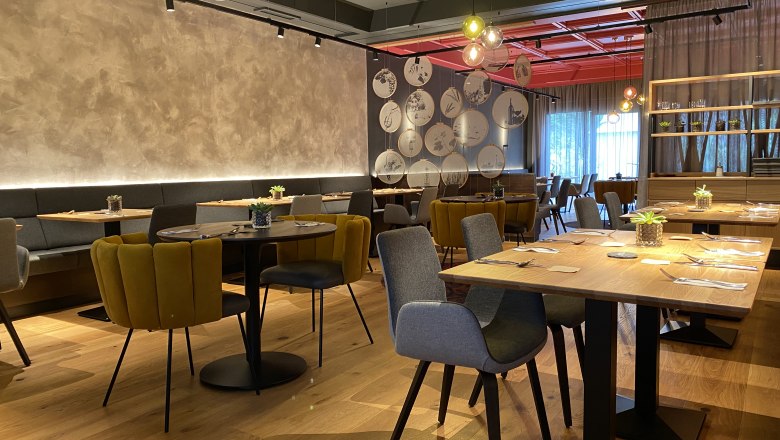 Restaurant und Vinothek, © Felix Sommer Modernes Restaurant mit stilvoller Einrichtung, Holztischen und gemütlichen Stühlen.