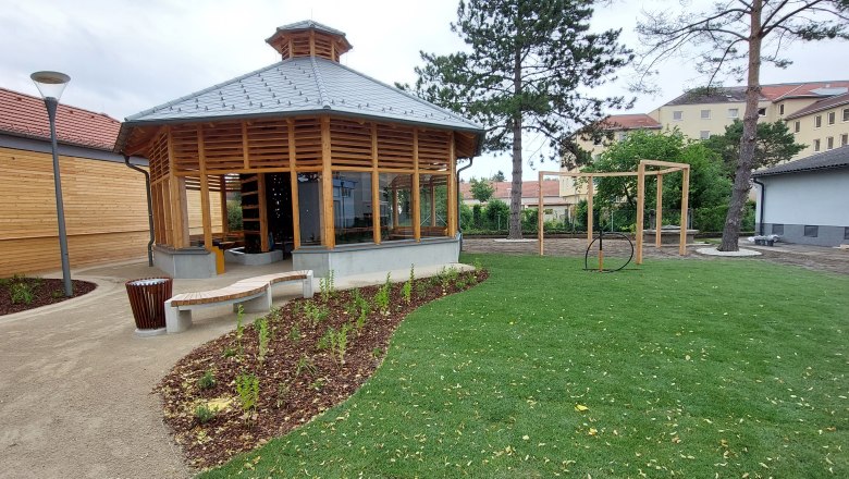 Inhalatorium, © Stadtgemeinde Gänserndorf Ein modernes Inhalatorium mit Holzkonstruktion und Glasfenstern in einem gepflegten Garten mit Rasen und Bäumen.