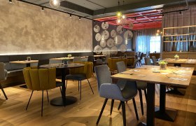 Restaurant und Vinothek, © Felix Sommer Modernes Restaurant mit stilvoller Einrichtung, Holztischen und gemütlichen Stühlen.
