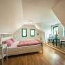 Winery Küssler, © Winzerhof Küssler Cozy bedroom with wooden floor, double bed, bedside tables, two chairs and a TV on the wall.