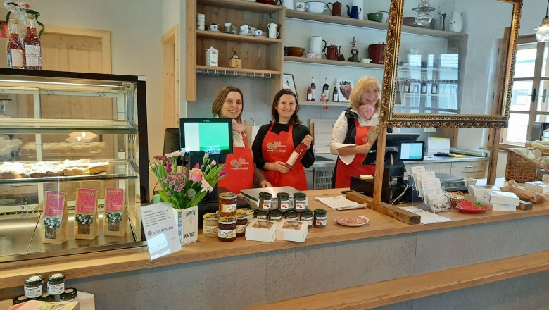 Drei Frauen in einem Geschäft mit Theke und Produkten.