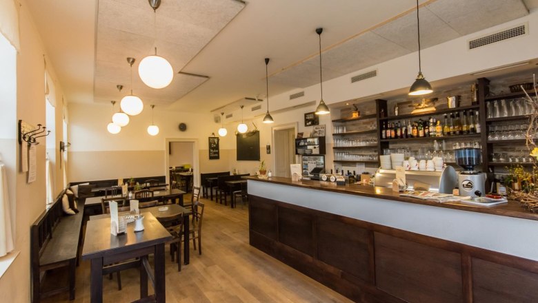 Interior view of a cozy pub with wooden furniture and bar.