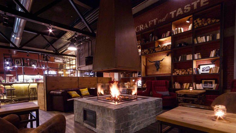 Cozy bar with fireplace and bookshelves.