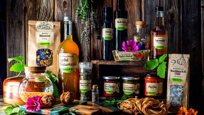 Various ADAMAH organic products arranged on a rustic wooden table.